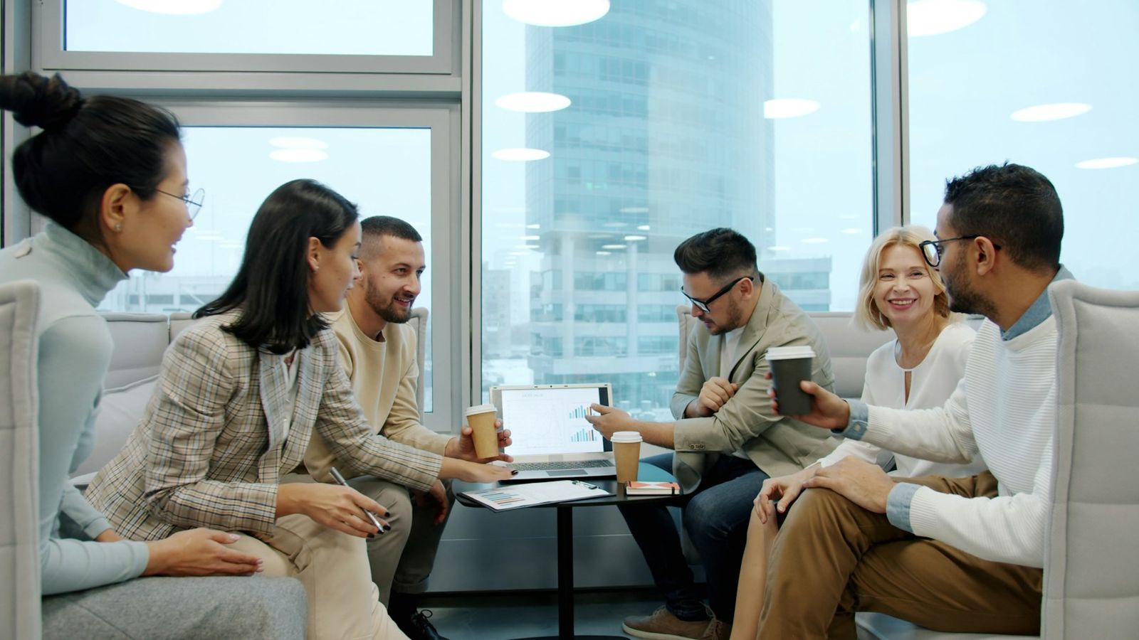 Team reviewing financial charts on a laptop in an office meeting